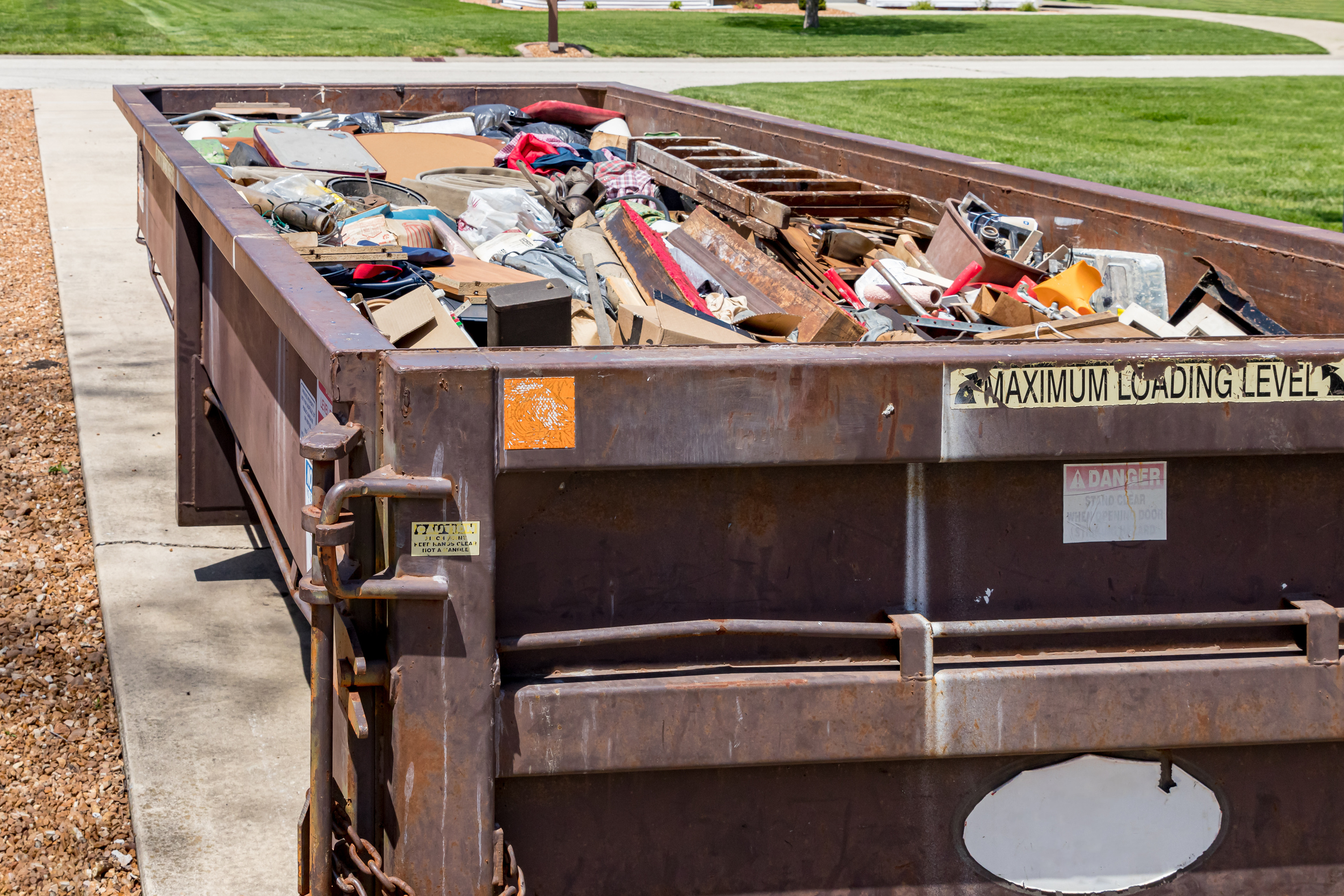 dumpster almost full of debris in residential driveway 